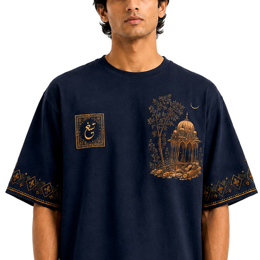Male model wearing a navy Mughal art oversized T-shirt with pavilion graphic and Urdu emblem