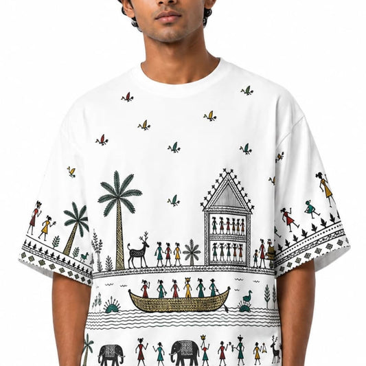 Male model wearing a white Saura-inspired oversized T-shirt with village artwork across the front and sleeves