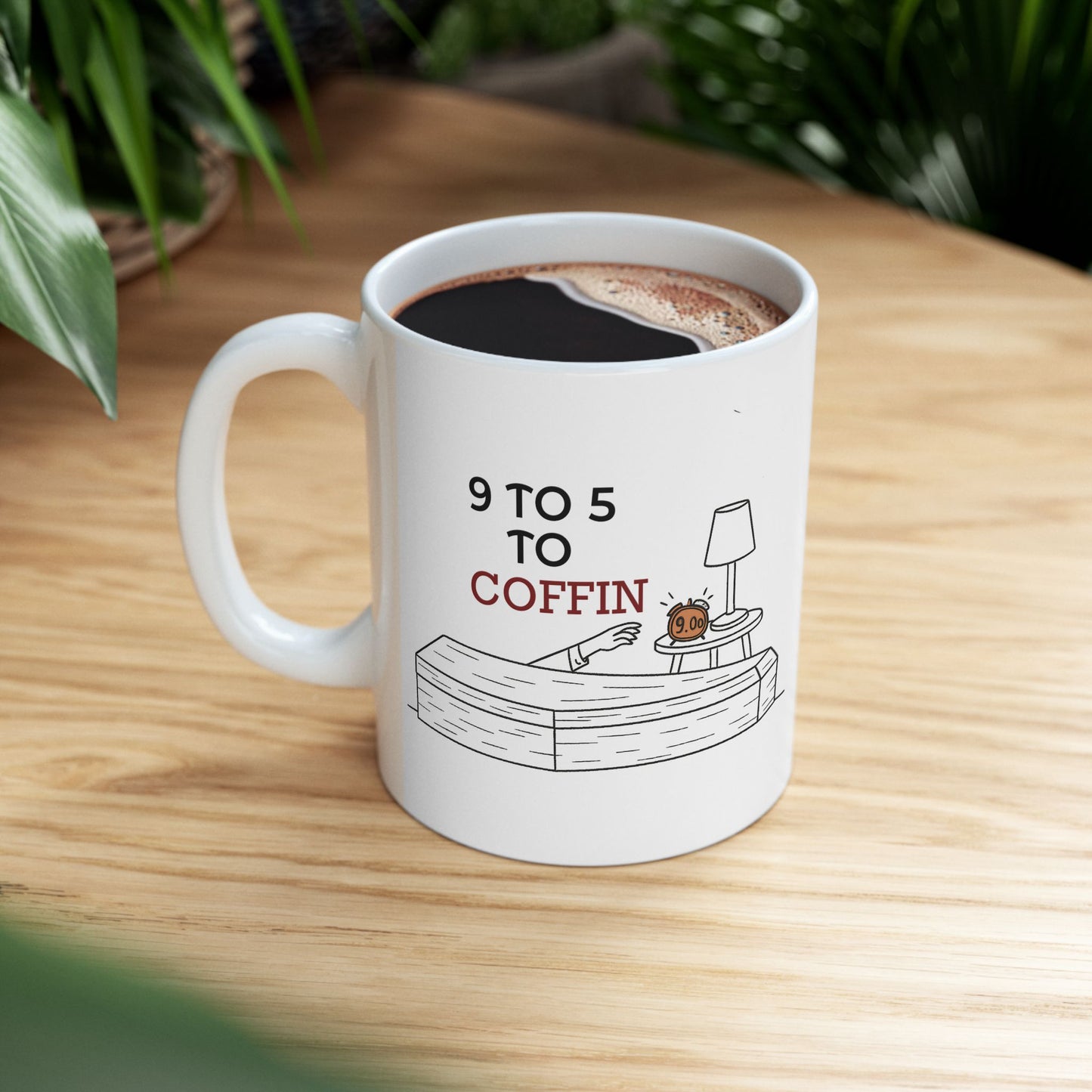 White Dead Inside mug with 9 TO 5 TO COFFIN typography and coffin illustration for burnout and job stress humor for introverts on a wooden table
