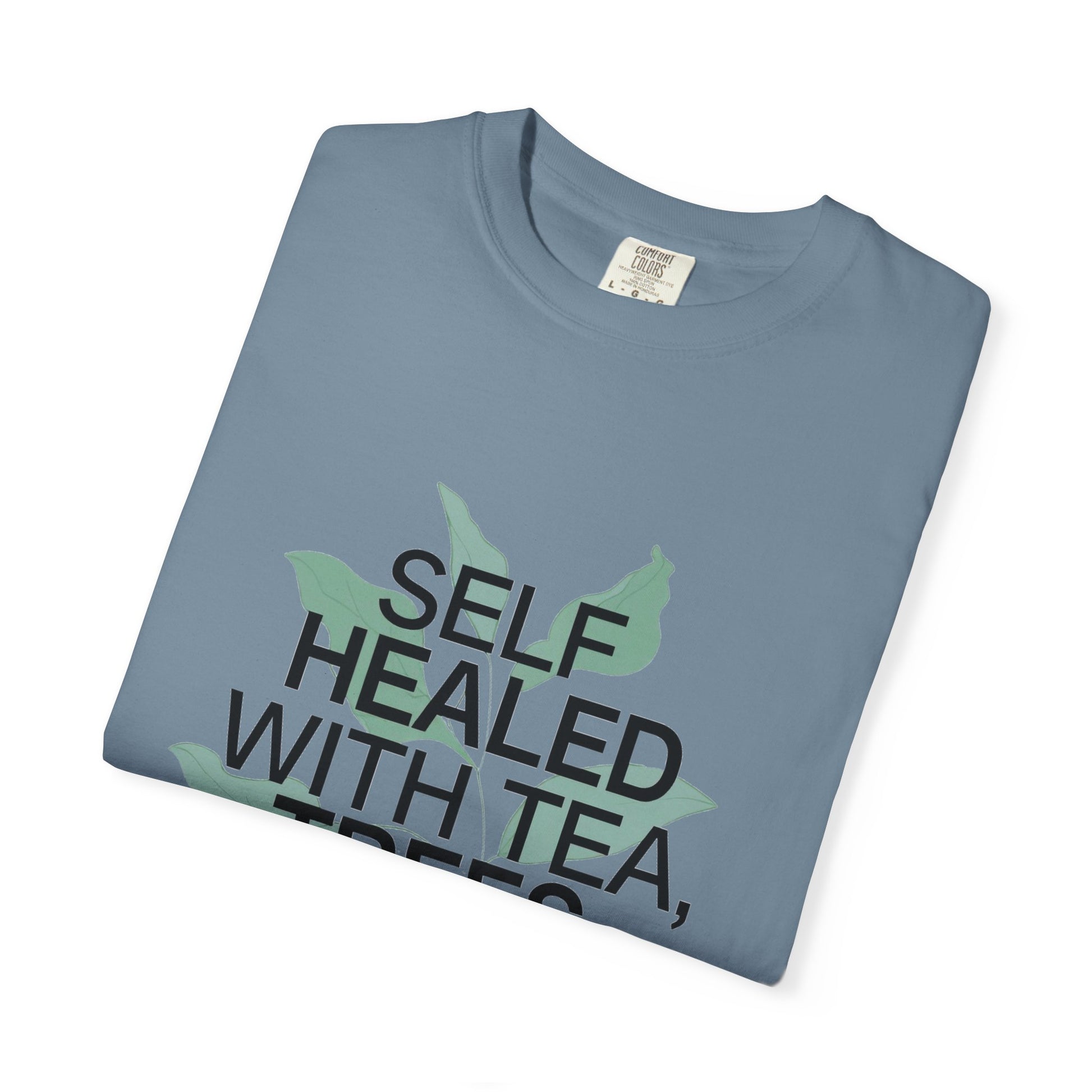 Folded blue t-shirt with text and leaf graphics on a white background
