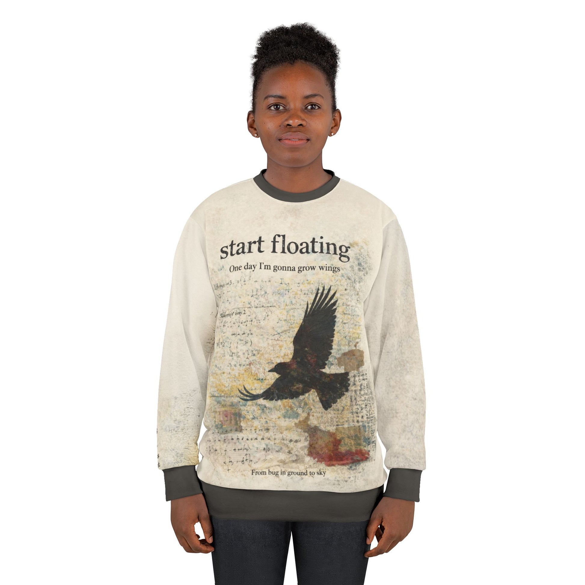 Female model wearing a dark academia raven graphic sweatshirt with a distressed raven in flight and vintage text reading “Start floating”