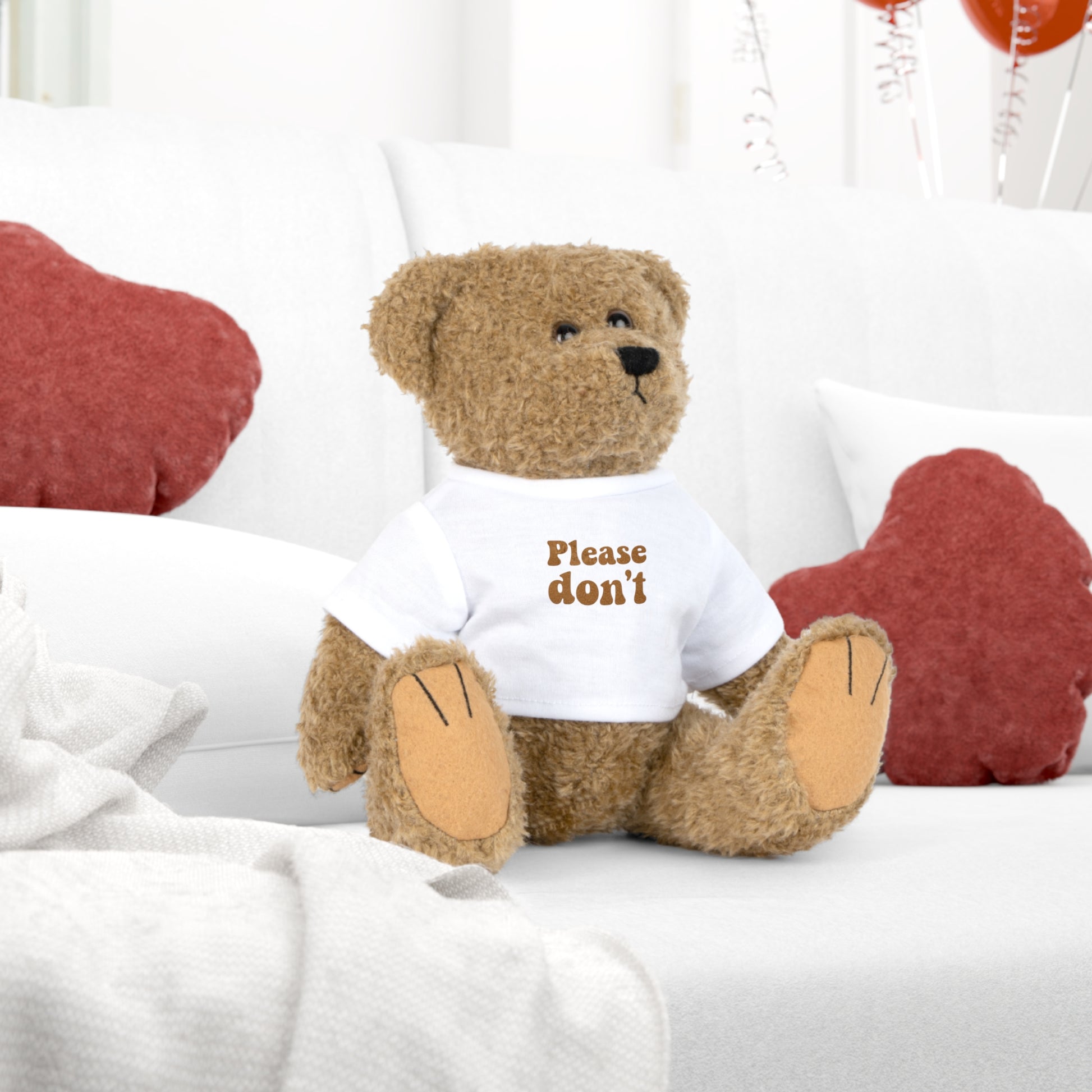 Teddy bear plush on a sofa wearing a “Please don’t” t-shirt, a quiet humor gift for calm homes and introvert spaces