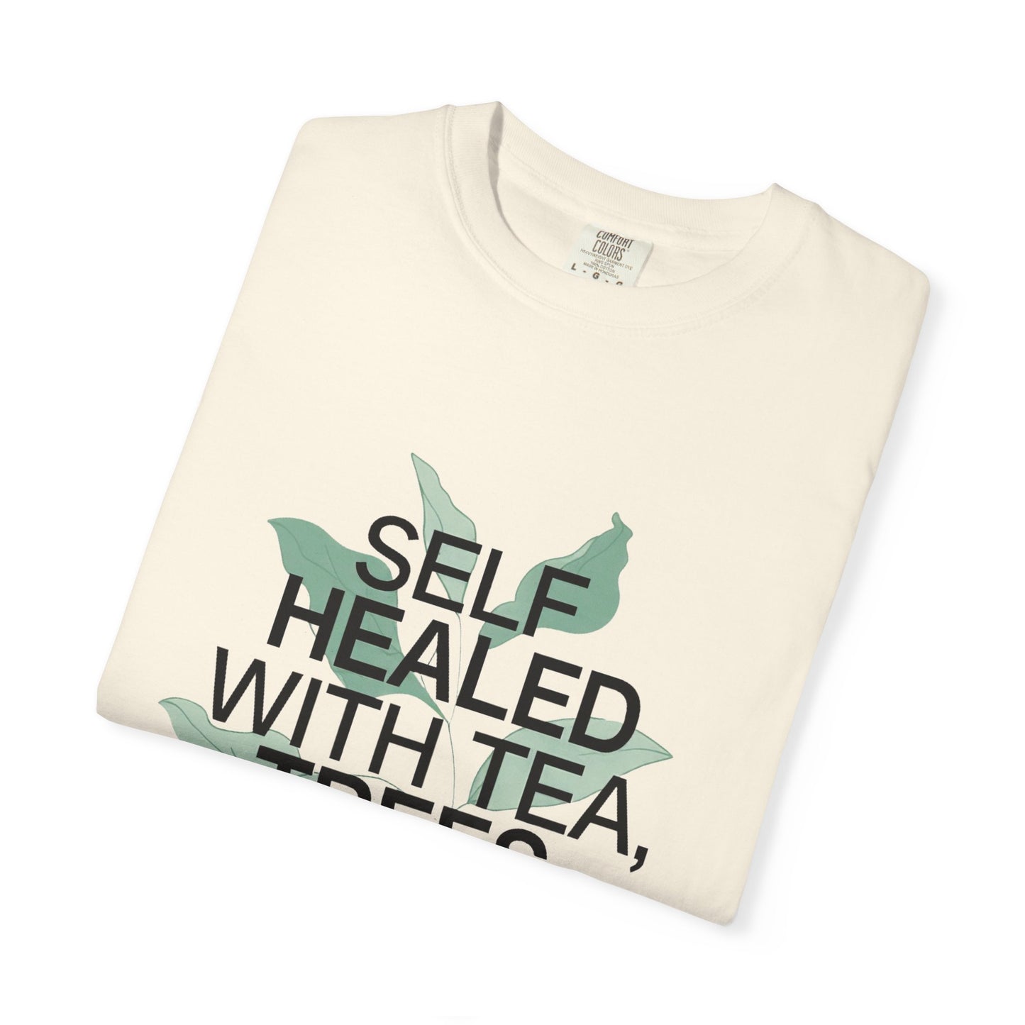 Folded cream-colored t-shirt with text and leaf graphics on a white background
