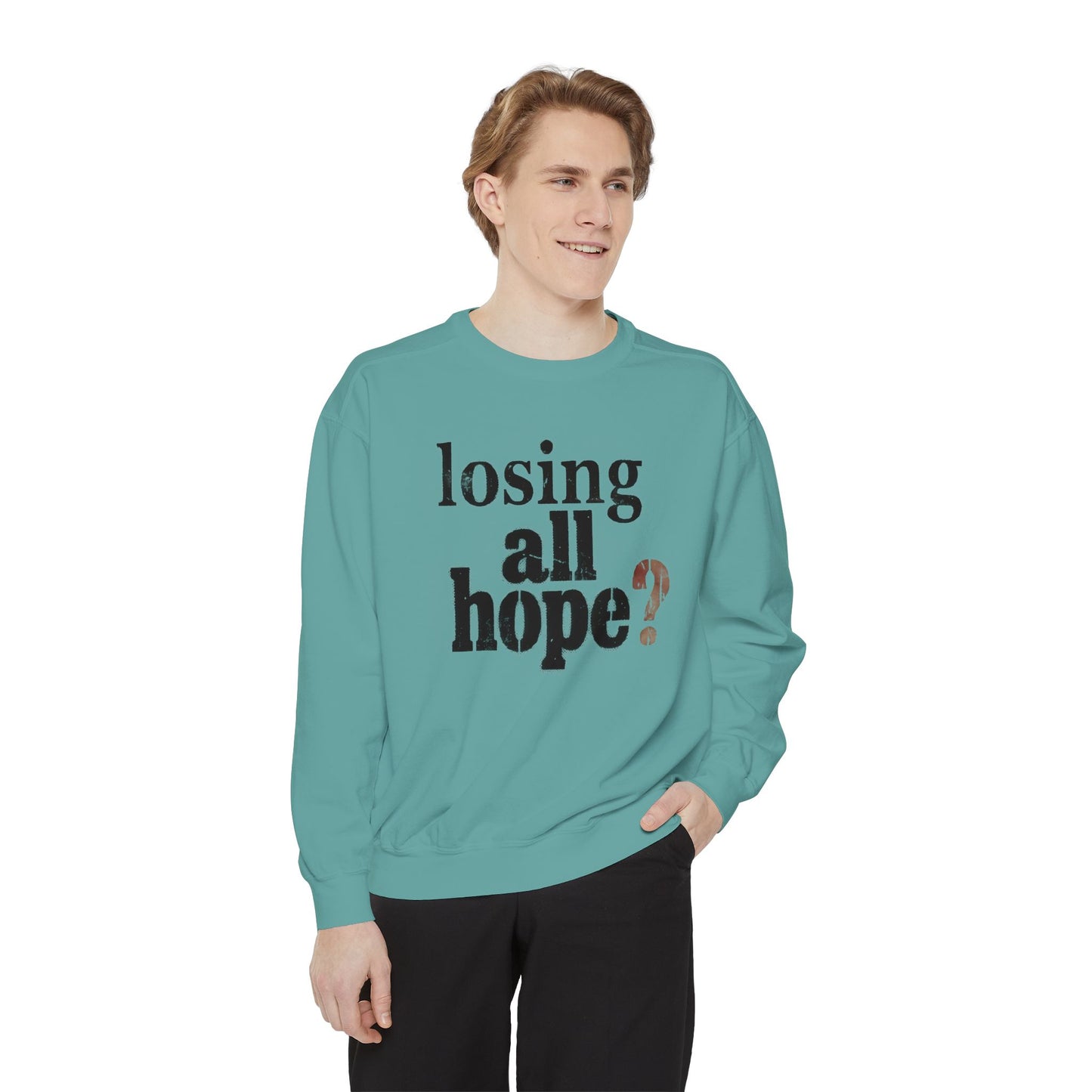 Person wearing a teal sweatshirt with text on a white background