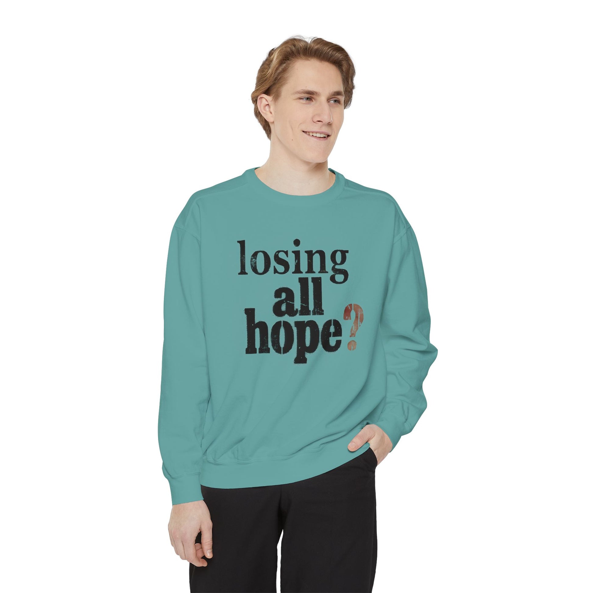 Person wearing a teal sweatshirt with text on a white background