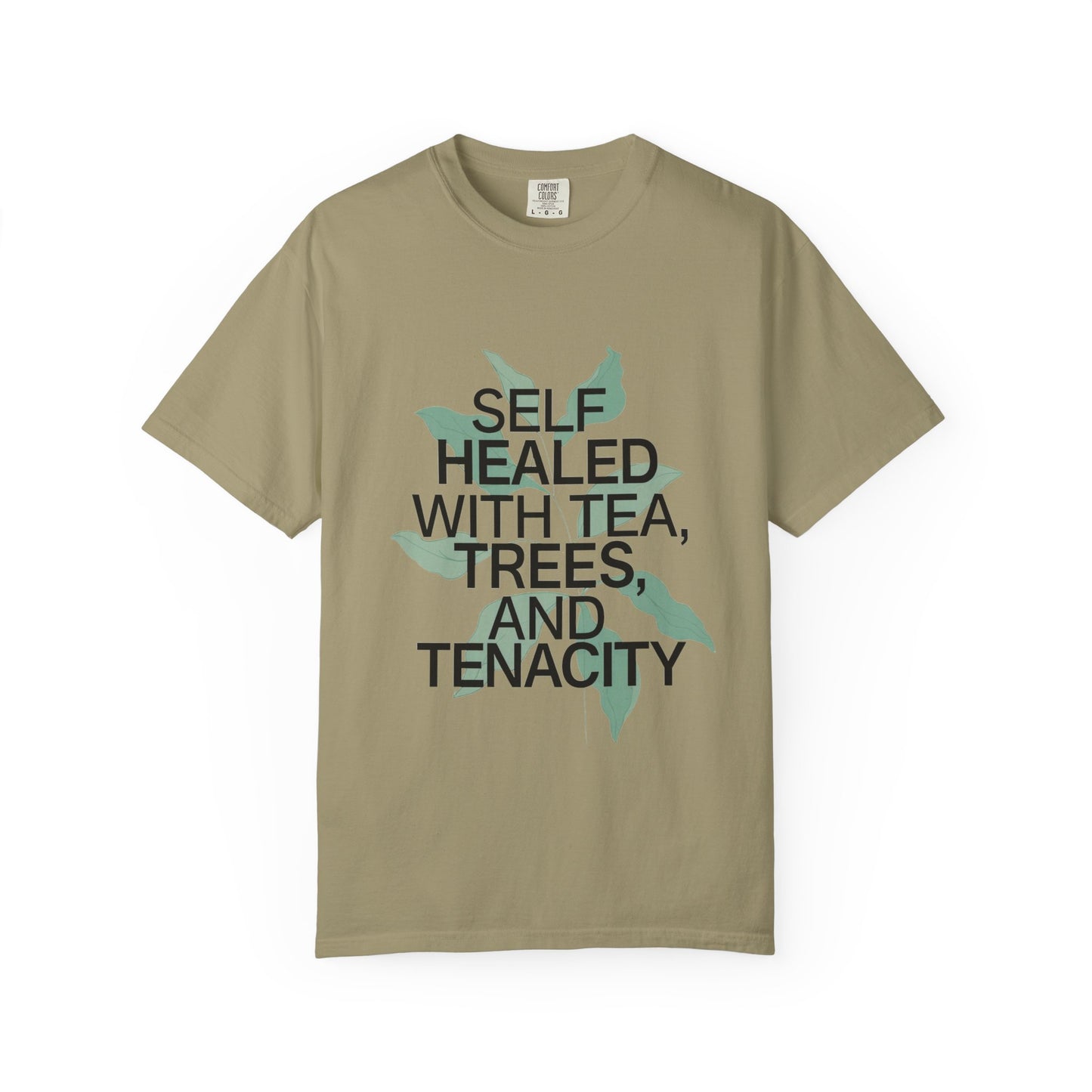 Beige t-shirt with text 'SELF HEALED WITH TEA, TREES, AND TENACITY' on a white background
