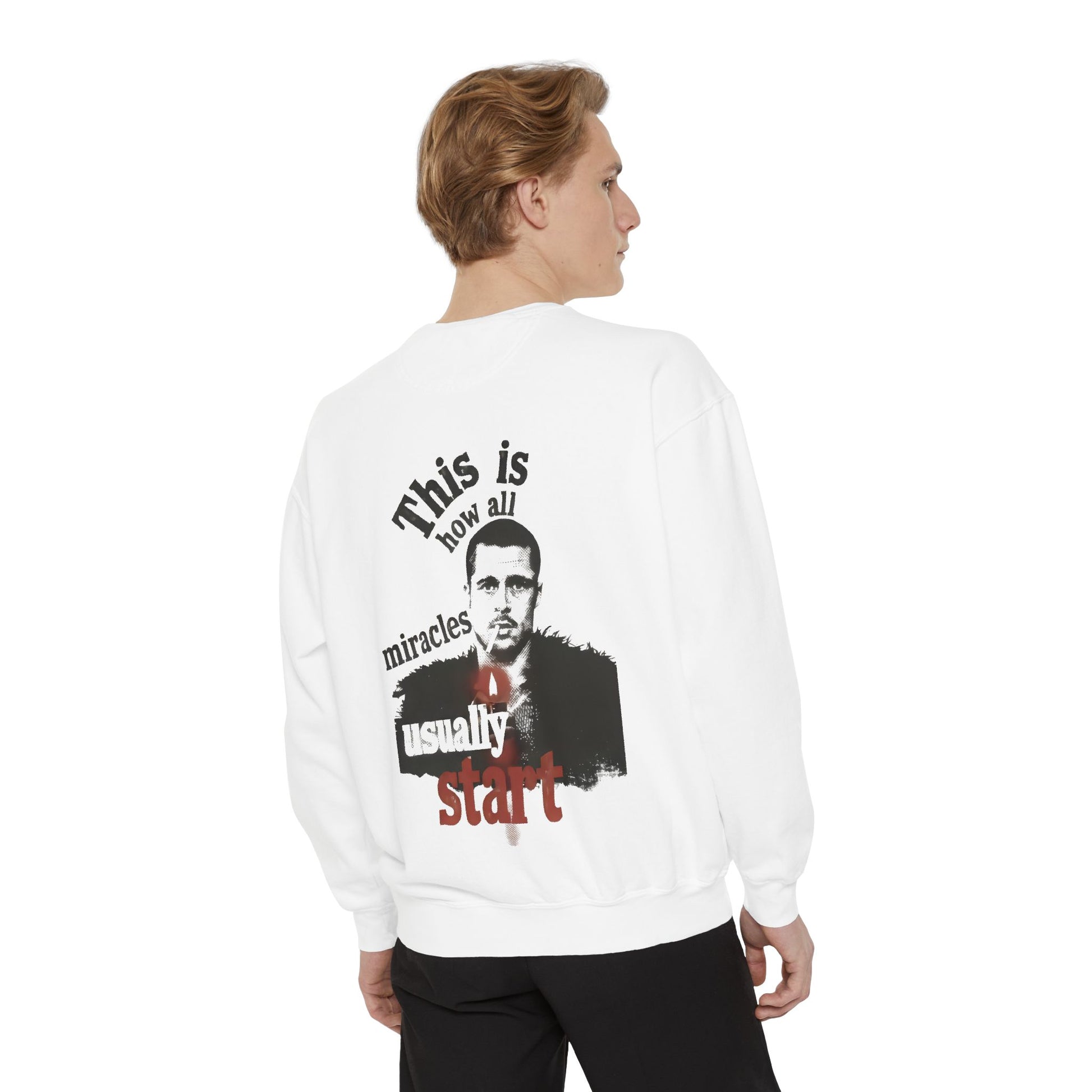 Person wearing a white sweatshirt featuring brad pitt illustration and typography "this is how all miracles usually start"