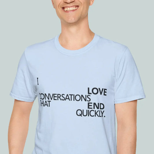 Person wearing a light blue t-shirt with text "i love conversations that end quickly" on a plain background