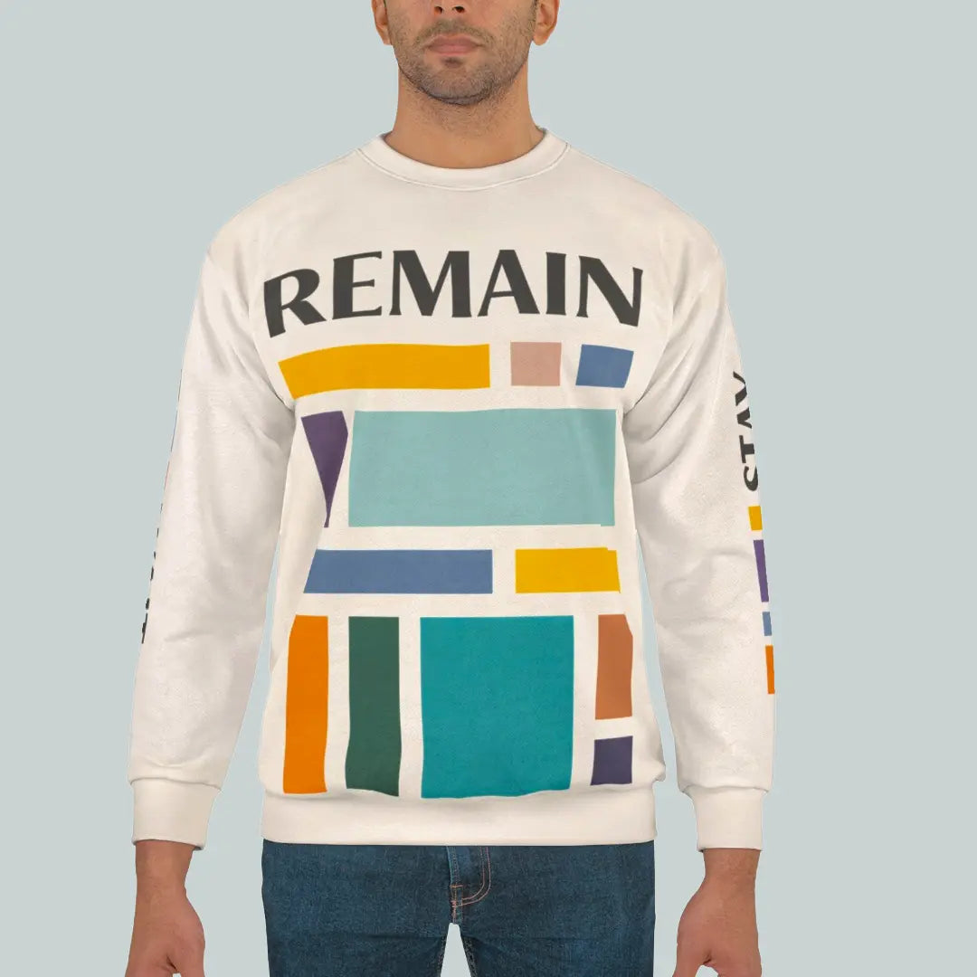 Male model wearing abstract color block sweatshirt with muted teal, mustard, rust and navy geometric print and the word REMAIN across the chest