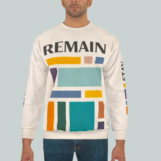 Male model wearing abstract color block sweatshirt with muted teal, mustard, rust and navy geometric print and the word REMAIN across the chest