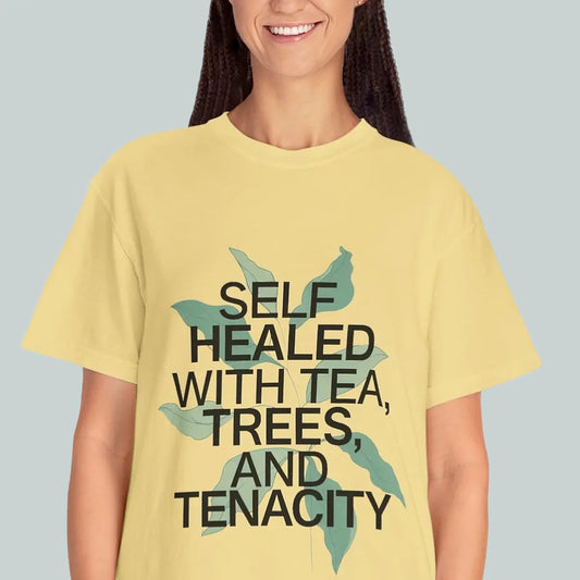Person wearing a yellow t-shirt with text and tree graphics on a plain background