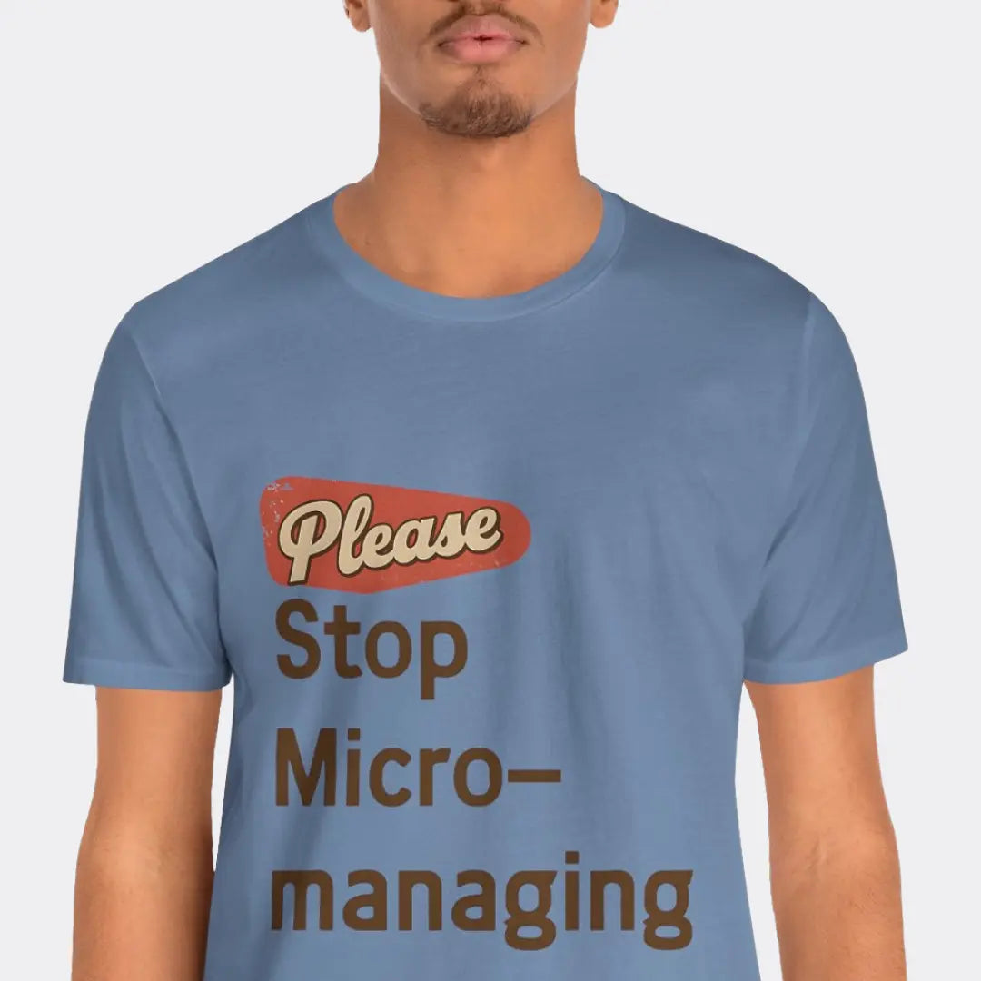 Person wearing the Please Stop Micromanaging tee with red and brown "Please Stop Micro-managing" text on a blue t-shirt