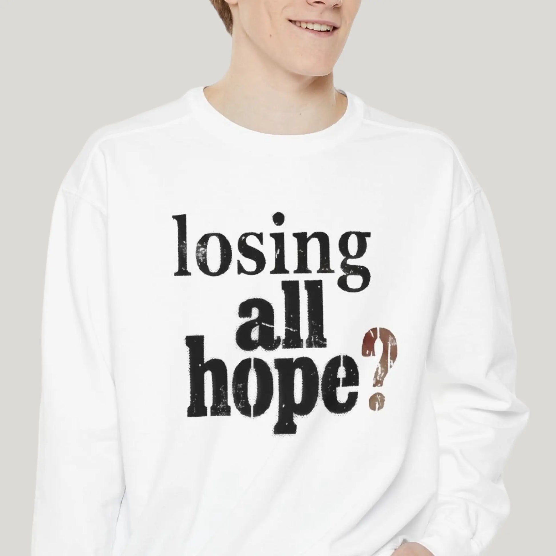 Person wearing a white long-sleeve shirt with 'losing all hope?' text on a plain background