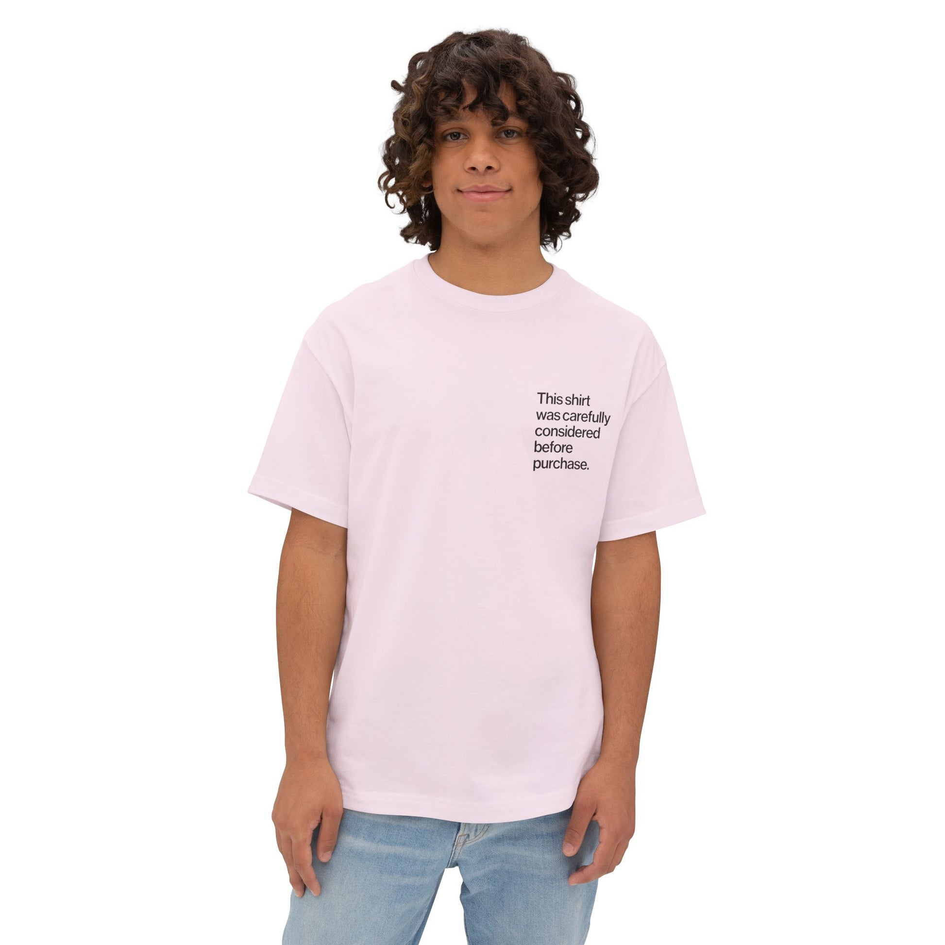 Person wearing a light pink Introvert T Shirt with minimalist Helvetica left-chest text, subtle design for quiet humor