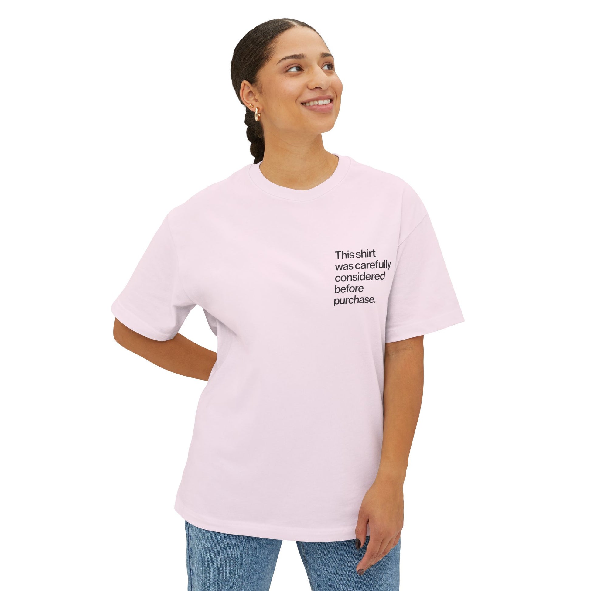 Person wearing a light pink Introvert T Shirt with minimalist Helvetica left-chest text, subtle design for quiet humor