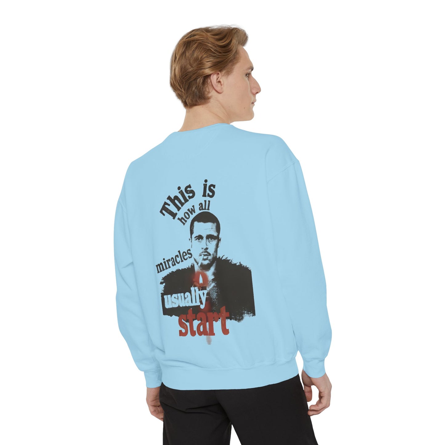 Light blue sweatshirt with graphic and text worn by a person on a white background