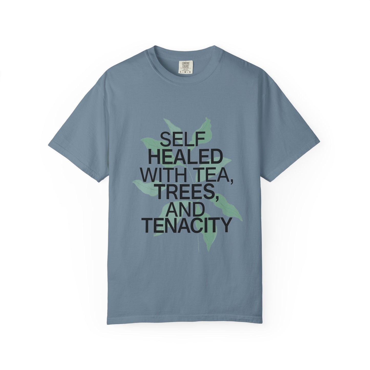 Blue t-shirt with text 'SELF HEALED WITH TEA, TREES, AND TENACITY' on a white background
