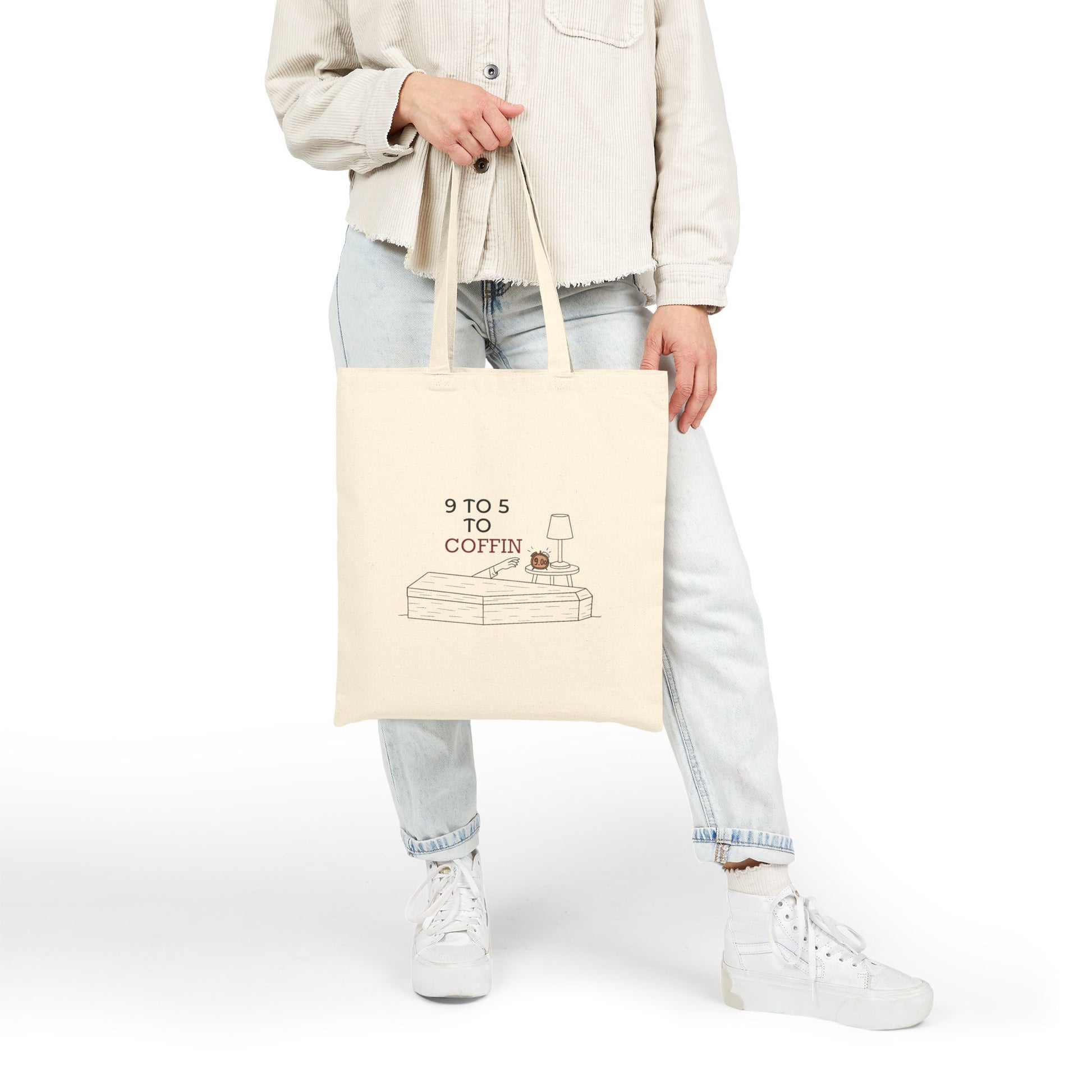 Person holding a Dead Inside tote bag with 9 TO 5 TO COFFIN typography and coffin illustration for burnout humor for introverts