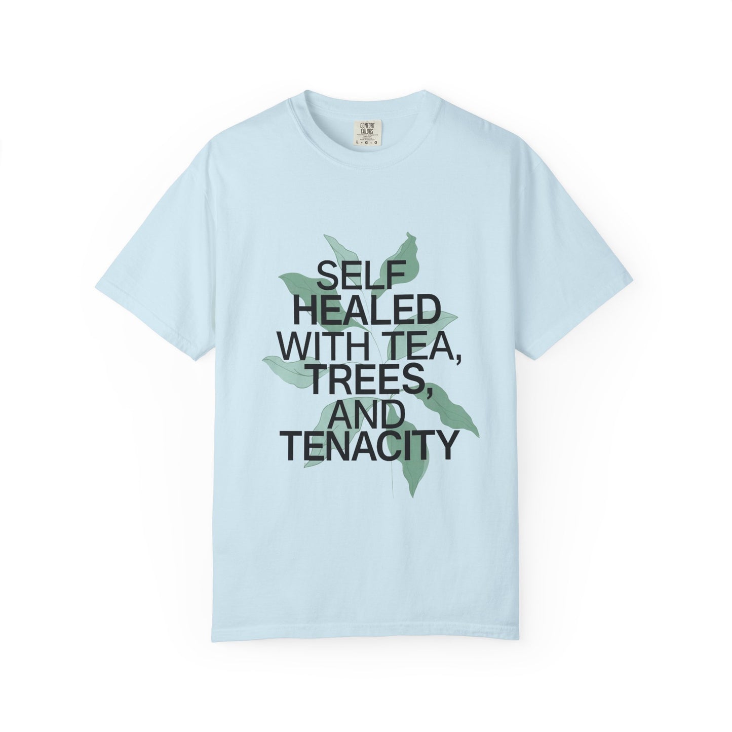 Light blue t-shirt with text 'Self Healed with Tea, Trees, and Tenacity' on a white background