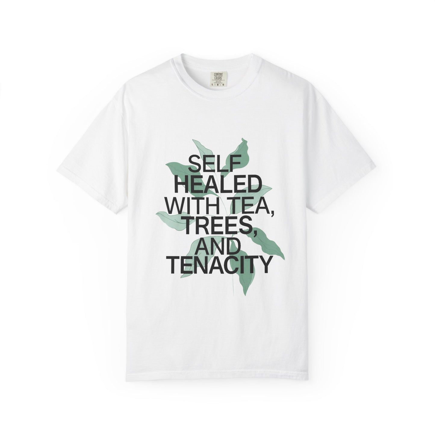 White t-shirt with text 'Self Healed with Tea, Trees, and Tenacity' on a white background