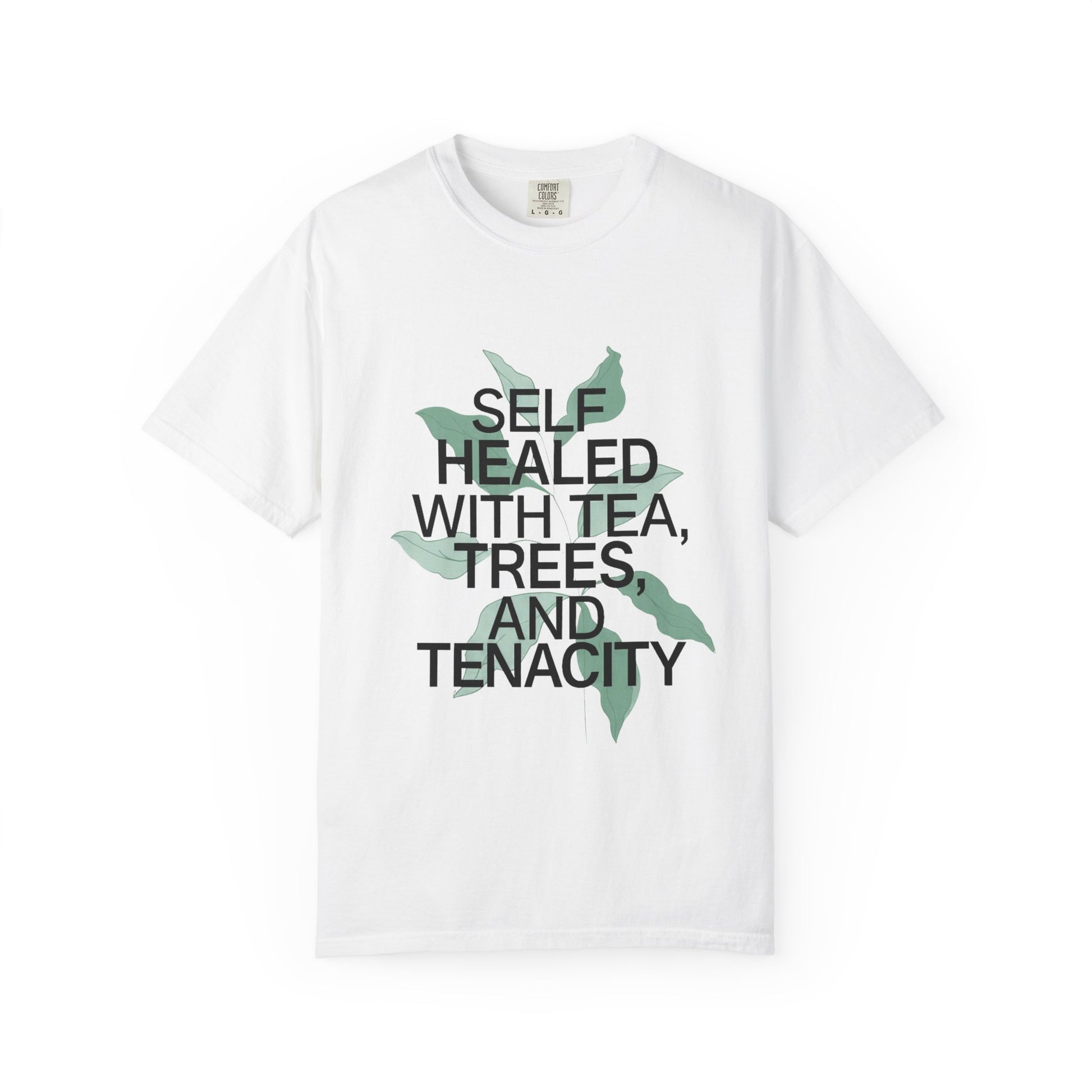 White t-shirt with text 'Self Healed with Tea, Trees, and Tenacity' on a white background