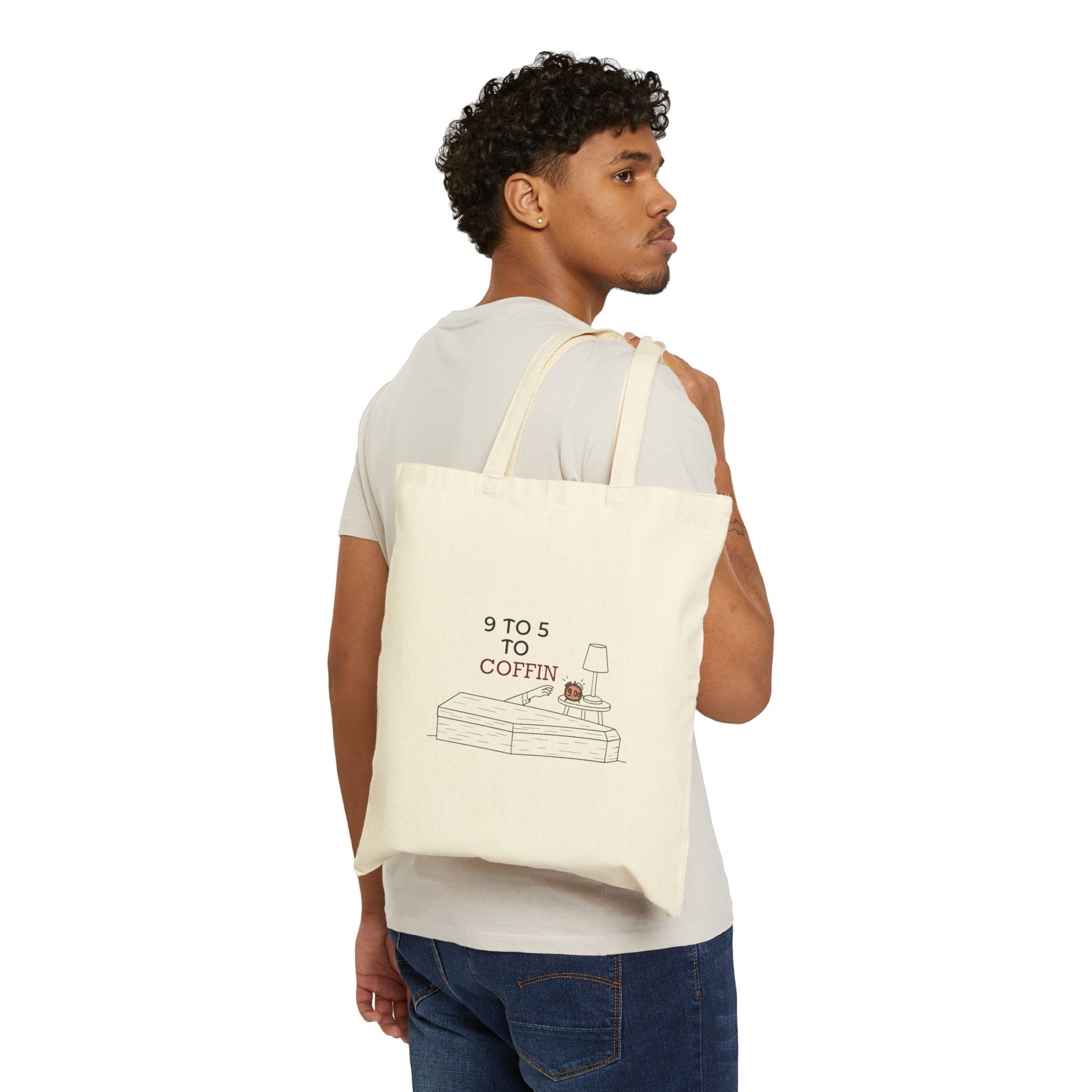 Man carrying a Dead Inside tote bag with 9 TO 5 TO COFFIN typography and coffin illustration for burnout humor for introverts