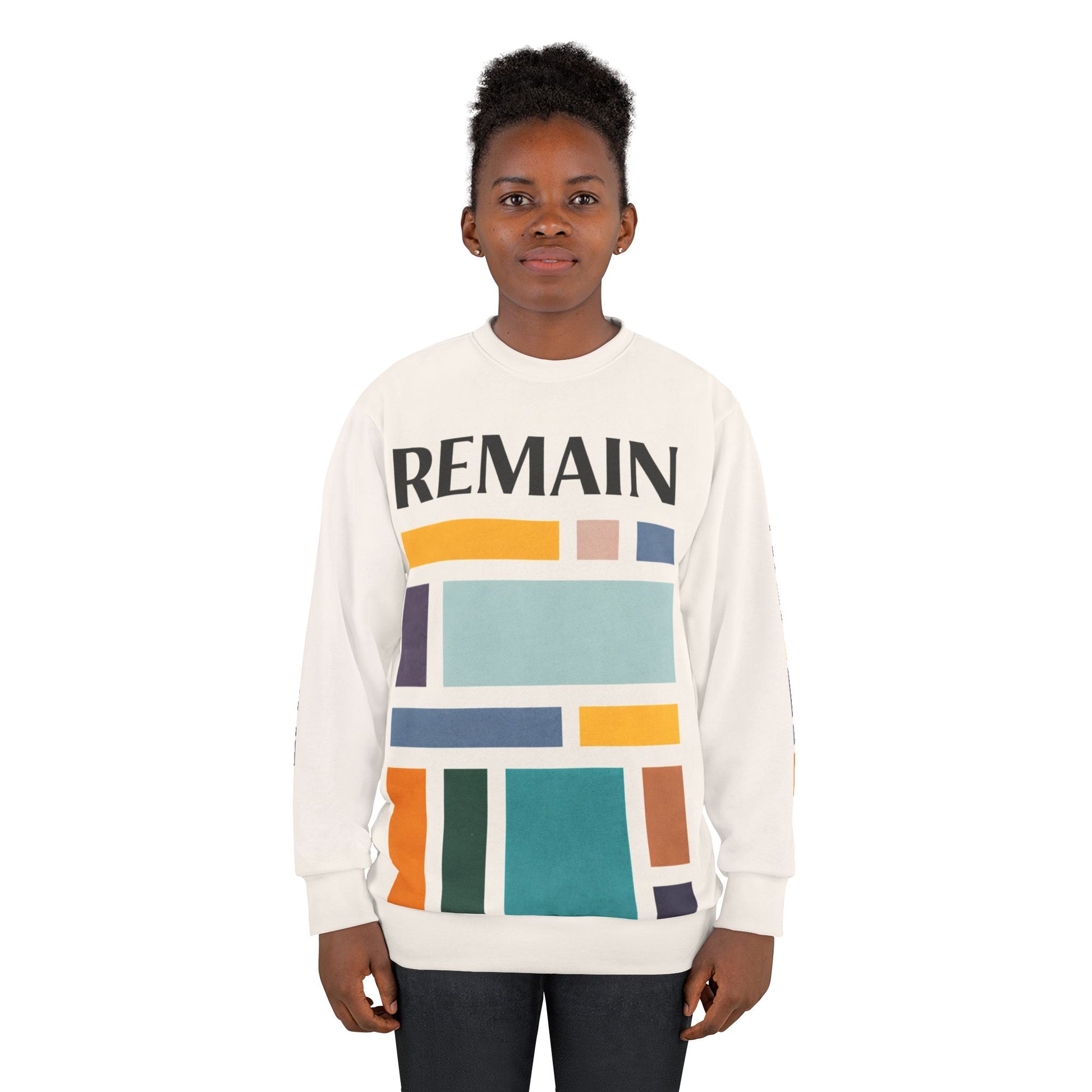 Female model wearing abstract color block sweatshirt with muted teal, mustard, rust and navy geometric print and the word REMAIN across the chest