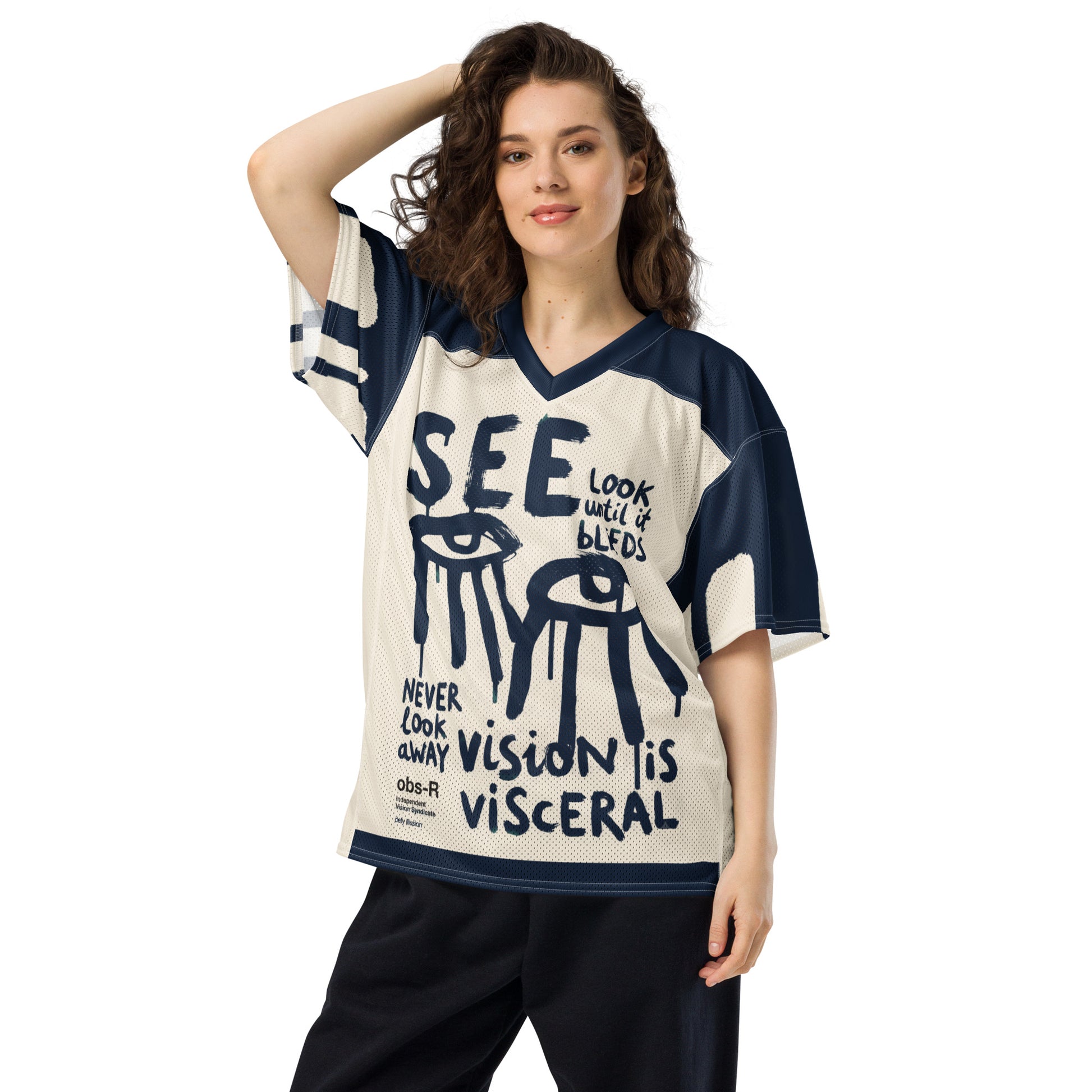 Model wearing the oversized Gravity of Perception mesh jersey. The off-white and navy front features raw typography, dripping eye motifs, and the text "SEE".