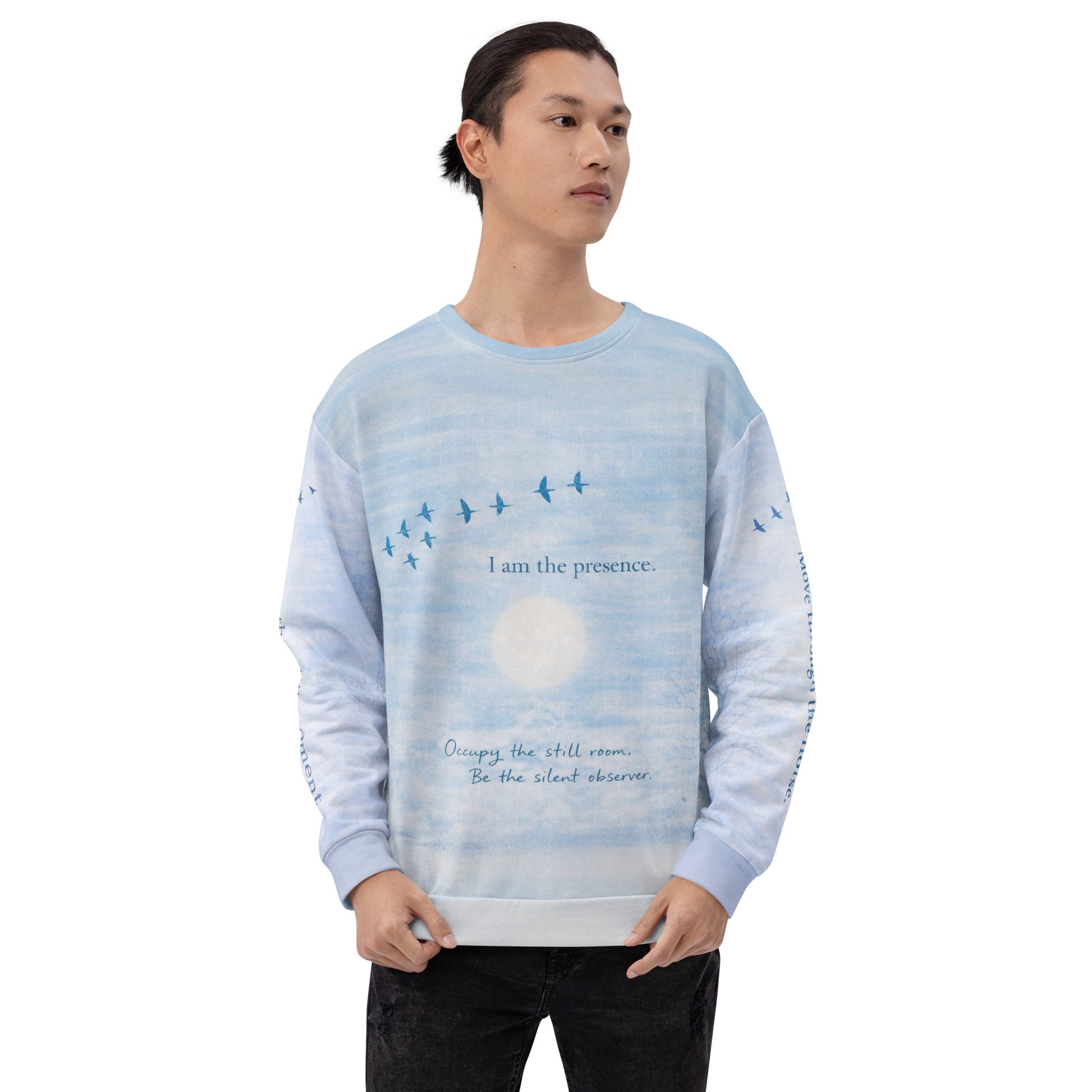 Front view of cloud print quote sweatshirt showing “I am the presence” text with birds flying across a serene sky design