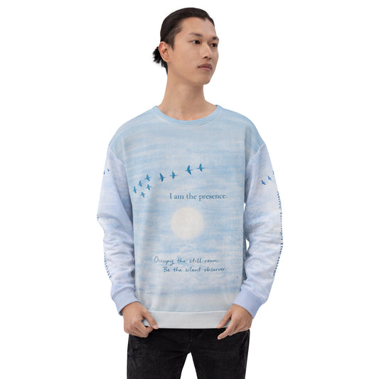 Front view of cloud print quote sweatshirt showing “I am the presence” text with birds flying across a serene sky design