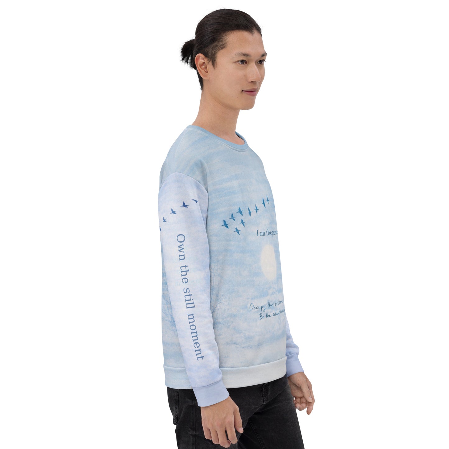 Side view of cloud print quote sweatshirt showing “Own the still moment” text printed along the sleeve