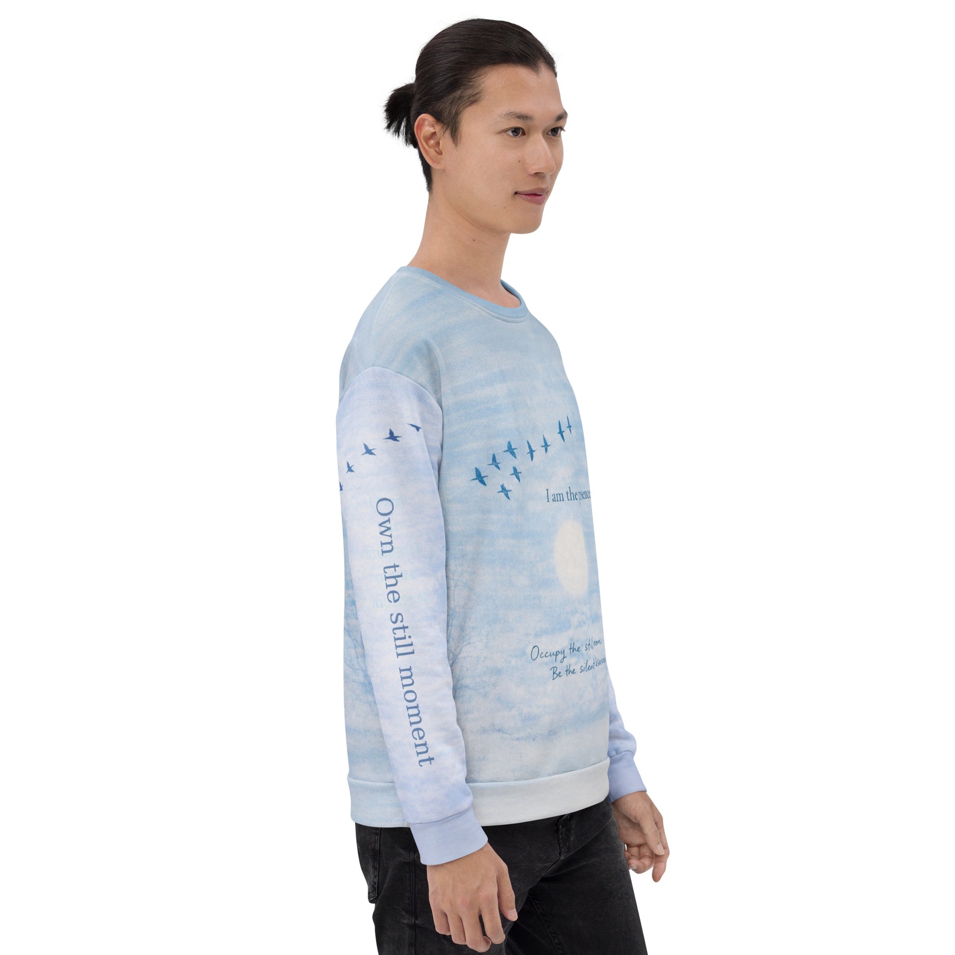 Side view of cloud print quote sweatshirt showing “Own the still moment” text printed along the sleeve