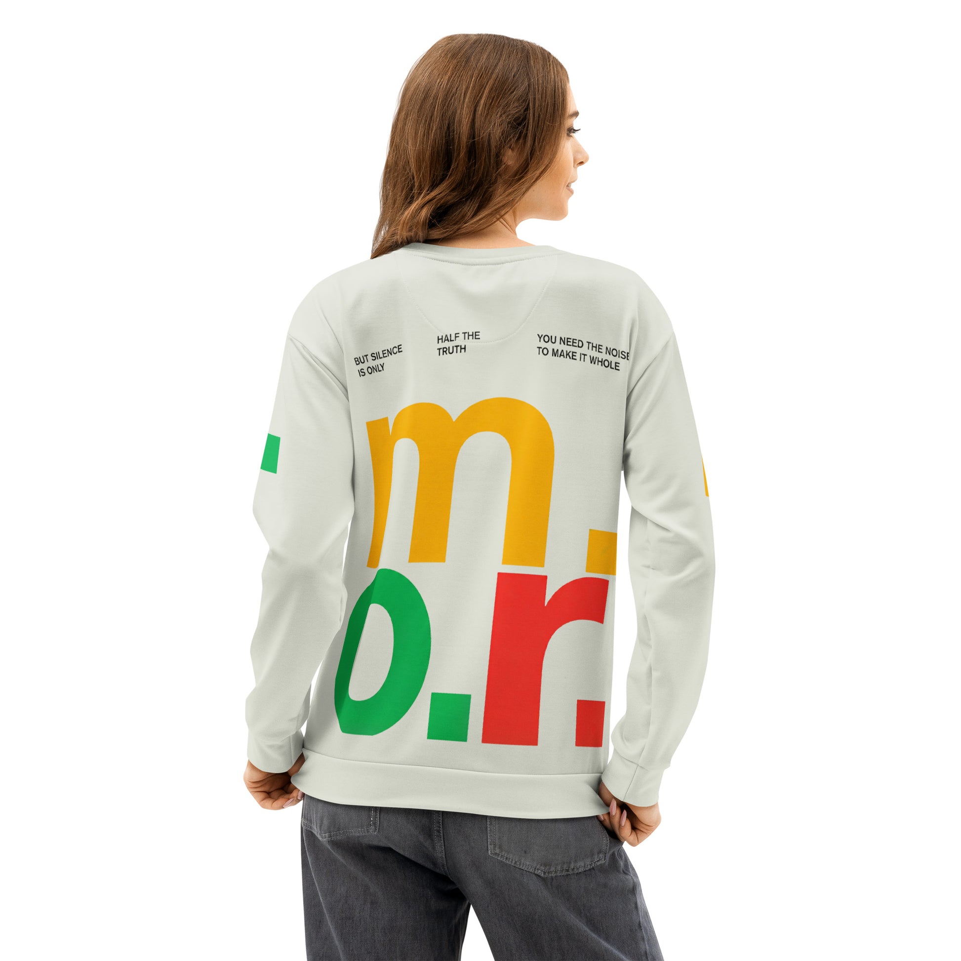 Rear view of a model wearing The Dialectic Crewneck, showcasing the vibrant "m.o.r." graphic. The design features large, stacked typography in primary yellow, green, and red against a cream-colored fabric, emphasizing the "More is More" maximalist aesthetic.