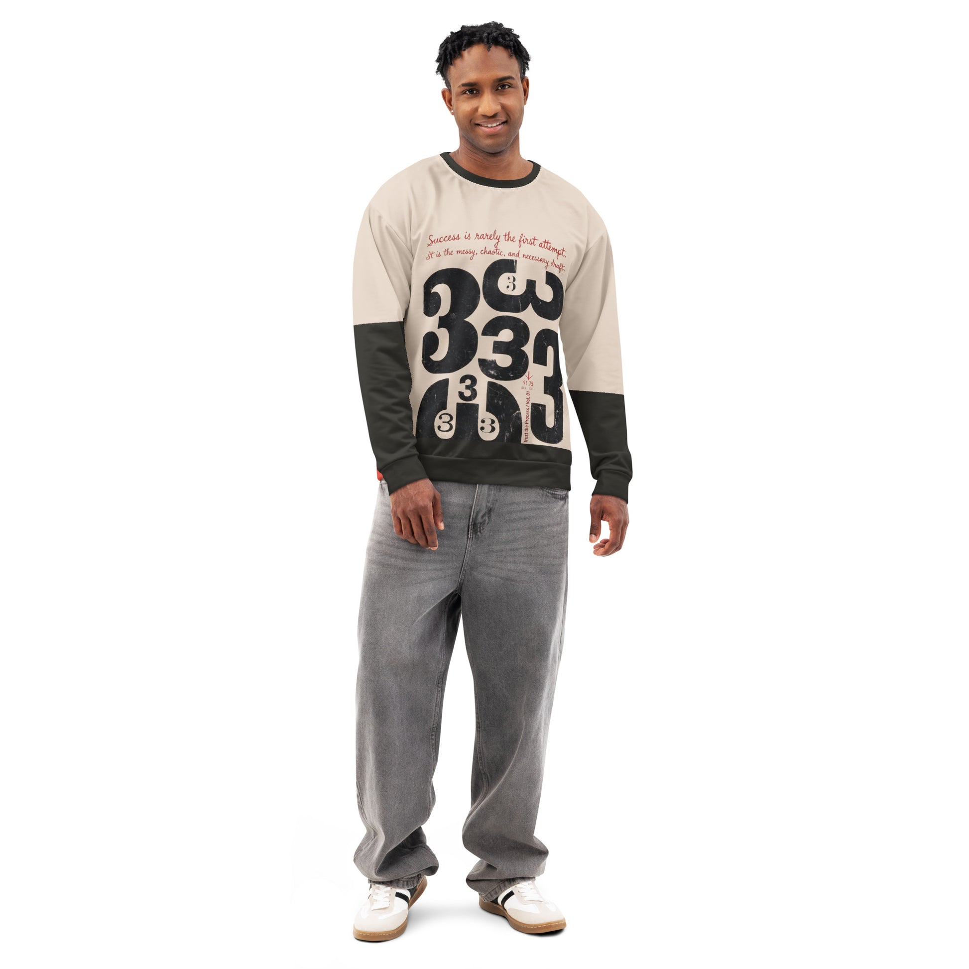 Model wearing a cream crewneck sweatshirt with black sleeves, featuring a distressed “333” typographic graphic and handwritten draft text on the front, styled with a relaxed unisex fit.