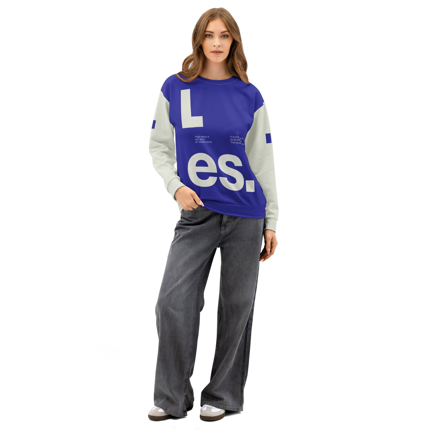 Female model wearing The Dialectic Crewneck in a relaxed fit. The image showcases the bold blue "L.es." graphic front design styled with grey wide-leg denim.