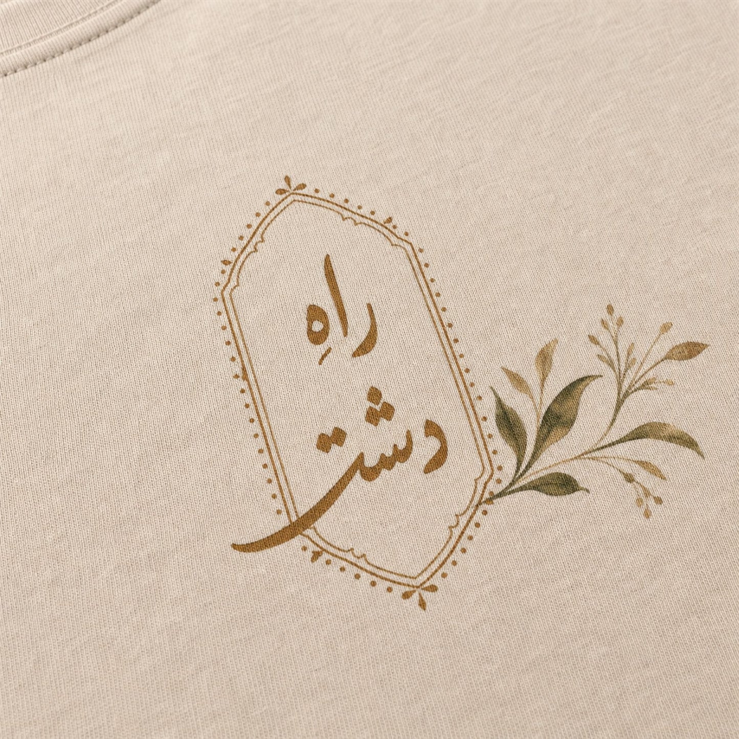 Raah-e-Dasht Oversized Botanical Tee close-up flat lay showing Urdu calligraphy print detail and fabric texture