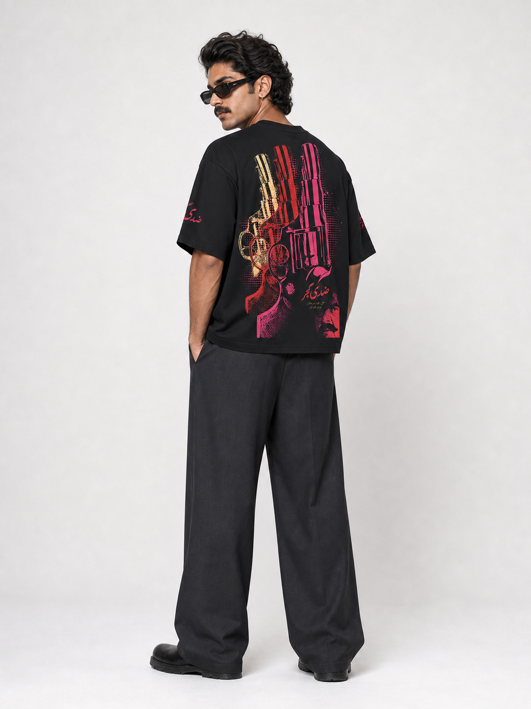 Male model wearing Ziddi Gujjar black oversized tee, back revolver print